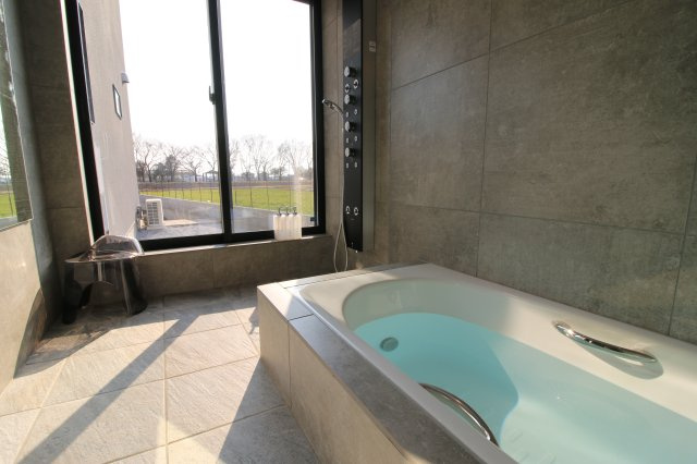 太田市粕川町中古戸建の浴室|掃き出し窓がついていて外に出られる浴室です。全面タイル張りとオーバーヘッドシャワーもついています。　