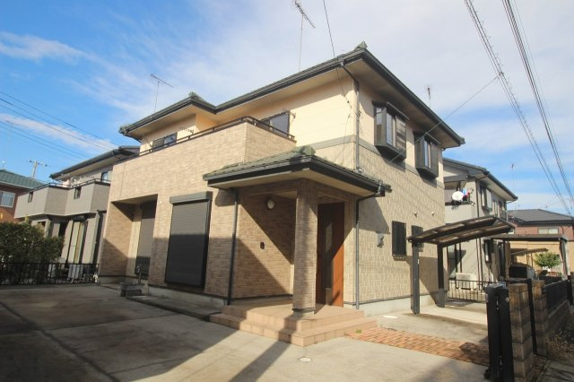 小山市羽川の外観|落ち着いた配色の外壁が魅力の、重厚感ある佇まいの一軒家です。広い駐車スペースが確保されており、複数台の駐車も安心！玄関ポーチは屋根付きで、雨の日の出入りも快適にできます。