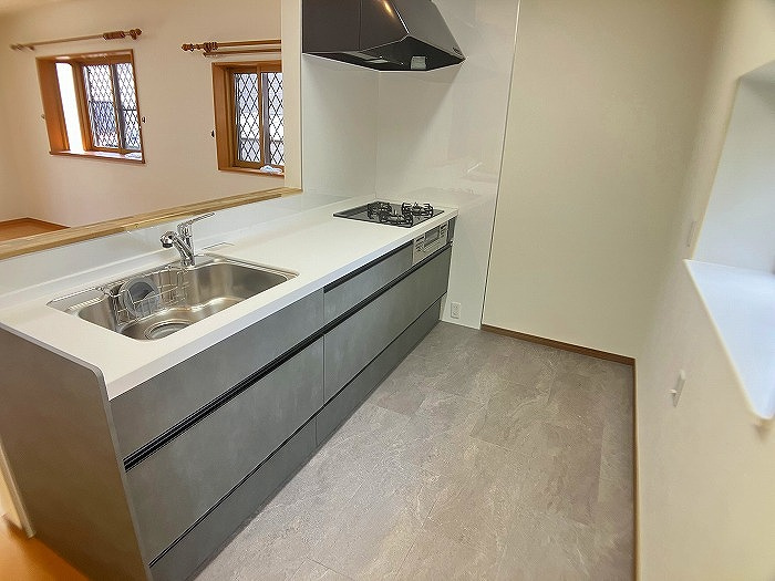 小山市羽川のキッチン|新品交換されたシステムキッチンは、広々とした作業スペースと収納が魅力！対面式で家族との会話もしやすく、毎日の料理がもっと楽しくなる使いやすさです。