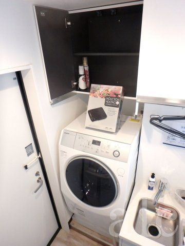 urban terrace 池袋 (アーバンテラス池袋)の内装|玄関横　嬉しい乾燥機付き全自動洗濯機つき。置いてあるのはIHキッチンです。電源プラグに接続することでご利用いただけます。