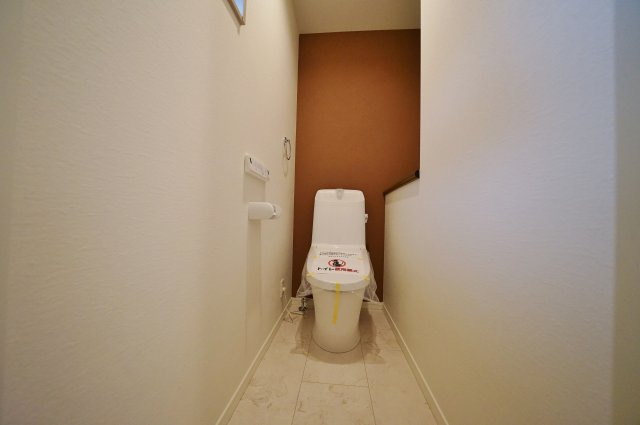 “魅せるLDK”と造作洗面のあるデザイン住宅｜仲介手数料無料のトイレ|落ち着いたアクセントクロスを採用。シンプルながらもデザイン性を感じる空間です。