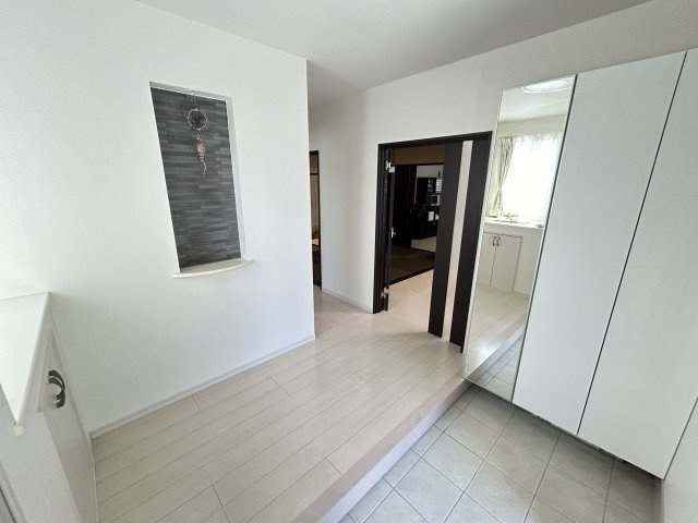 暮らしやすさと格調を両立するプレミア邸宅　熊本県熊本市北区龍田の玄関|玄関収納も大容量！靴が多い家庭でも安心です。アクセントクロスが目を引くニッチには何を飾りますか？