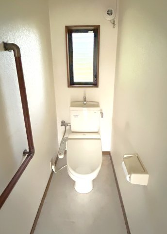 心が深呼吸する緑の暮らし　熊本県阿蘇市永草のトイレ|手すり付きの温水洗浄便座トイレ。ルーバー窓から阿蘇のフレッシュな空気を取り込めます。