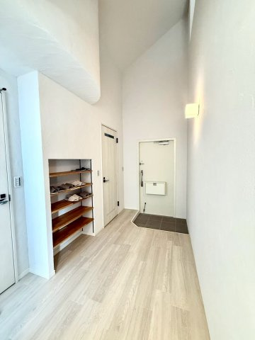 ガーデン南山手の玄関|高天井とアーチ形状が印象的な玄関・廊下。間接照明の柔らかな光が、邸宅のような上質さを感じさせます。