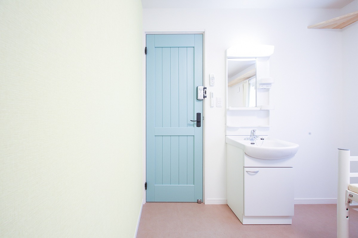 ぬこハウス小岩の洋室|個室２０６号室：個室に専用洗面台、キャットウォーク、マットレス、エアコン、カーテン、室内外洗濯物干しを完備。個室扉：グリーン、アクセントクロス：イエロー。
