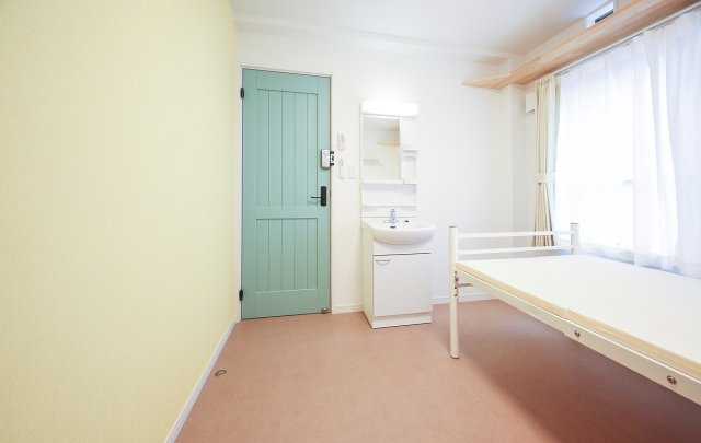 ぬこハウス小岩の洋室|個室２０６号室：個室に専用洗面台、キャットウォーク、マットレス、エアコン、カーテン、室内外洗濯物干しを完備。個室扉：グリーン、アクセントクロス：イエロー。
