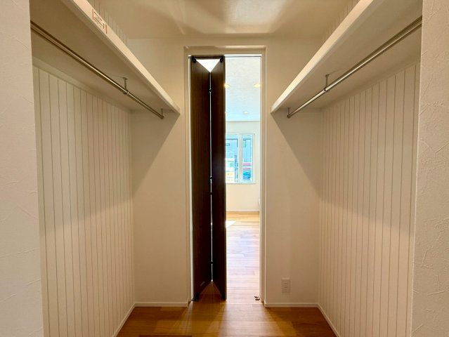 吾川郡いの町　新築一戸建ての収納|両側にハンガーパイプを備えたウォークインクローゼット。収納力たっぷりで衣替えもスムーズ