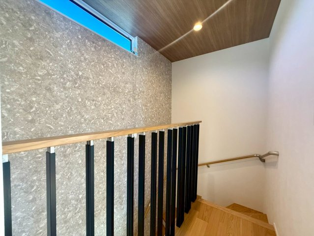 吾川郡いの町　新築一戸建てのその他|木目天井と質感のあるアクセント壁が、上品な雰囲気を演出する階段スペース。