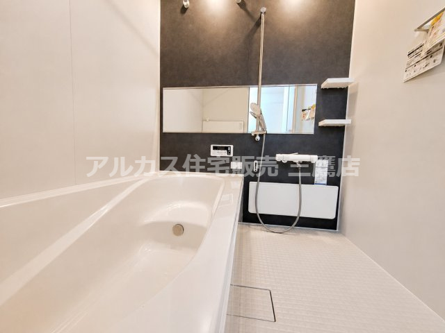 【内覧動画公開中！】三鷹市牟礼５丁目 井の頭線 三鷹台駅 新築戸建の浴室|横長ミラーとダークカラーのアクセント壁が印象的な浴室。棚付きで小物も置きやすい空間です。
