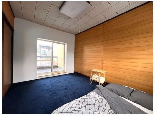 大山崎町円明寺脇山の洋室|二階西側洋室です。ダークブルーのカーペットと壁面の木目調が相性良く調和した落ち着いた雰囲気の居室です。
