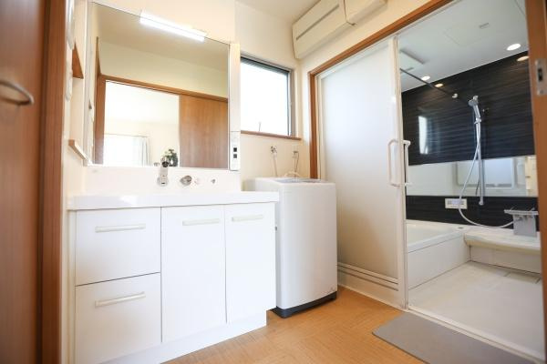 角子原　戸建ての独立洗面台|大きな鏡と収納スペースが充実した洗面所です。室内は明るく清潔感のある空間が広がります。洗濯機置き場も確保されており動線が良好です。引き戸仕様で使い勝手も良いです。