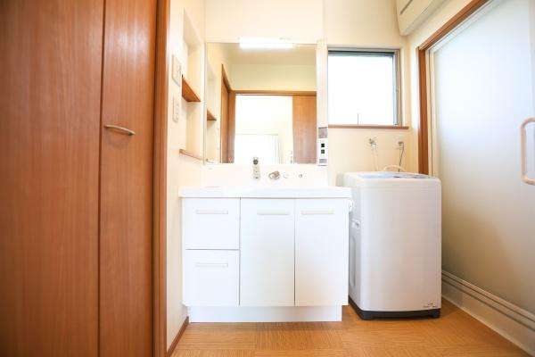 角子原　戸建ての独立洗面台|収納棚とミラーが備わった洗面台で毎日の使い勝手に配慮されています。洗面ボウルが広めに設計されており手入れもしやすい造りです。木目調の扉が空間に温かみをプラスしています。すっきりとした印象の洗面所です。