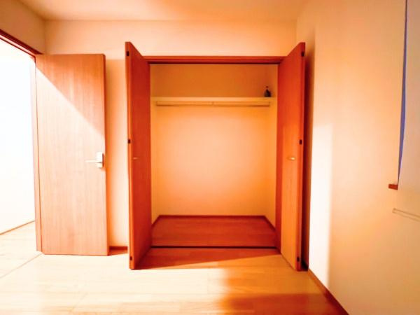 角子原　戸建ての収納|扉が大きく開く収納スペースでスムーズに物の出し入れができます。クローゼット内にハンガーパイプが備え付けられており衣類を整理しやすい設計です。木目調のデザインが空間に落ち着いた雰囲気を与えます。