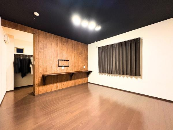 角子原　戸建ての洋室|温かみのある木目調のアクセント壁が印象的です。広々とした空間で開放感があります。おしゃれなカウンターが設置されています。落ち着いた色合いの床材を使用しています。収納スペースも確保されています。