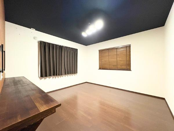 角子原　戸建ての洋室|落ち着いた色合いのフローリングが印象的な洋室です。天井のアクセントカラーが個性を引き立て窓にはシンプルなカーテンとブラインドが設置されています。広々とした空間でさまざまな用途にご利用いただけます。