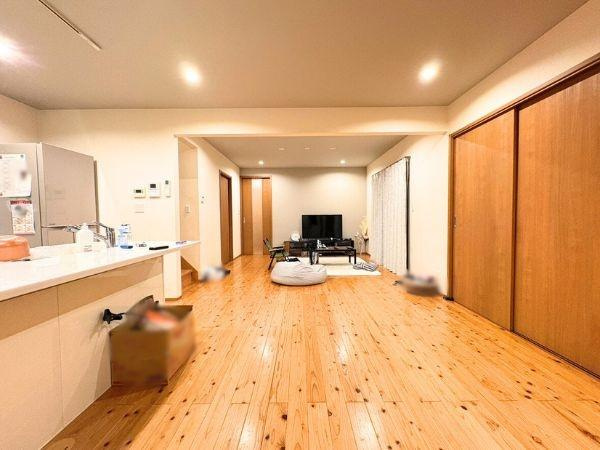 角子原　戸建ての居間・リビング|広々とした空間設計が特徴のリビングです。木目調のフローリングが温かみを感じさせます。引き戸があり空間の使い方を柔軟に調整できます。天井の埋め込み照明が室内を明るく照らします。