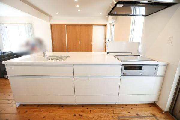 角子原　戸建てのキッチン|広々とした造りが特徴のキッチンです。清潔感のあるカラーと収納スペースが魅力となっています。ダウンライトがキッチンスペースを明るく演出しています。木目調の床が空間を温かくまとめています。