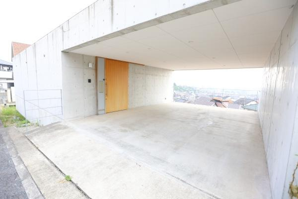 青葉台　戸建ての駐車場|コンクリート打ちっぱなしのデザインが印象的な駐車場です。雨風をしのげる屋根付きで車の出し入れもスムーズに行えます。ゆとりのあるスペースで大型車も駐車しやすい仕様です。