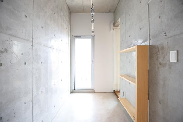 青葉台　戸建ての玄関|コンクリート打ちっぱなしの玄関がスタイリッシュな印象を与えます。明るい光が差し込む入口で開放感があります。玄関の一角に便利な棚が設置されています。シンプルなデザインが魅力的です。
