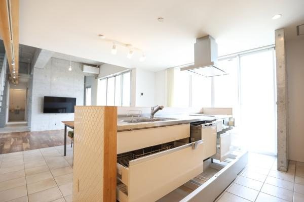 青葉台　戸建てのキッチン|開放的な空間に配置されたキッチンです。大きな引き出し収納が備わっており整理しやすい設計です。作業スペースが広くシンプルで使いやすい点が特徴です。明るい光が差し込むため清潔感を感じられます。