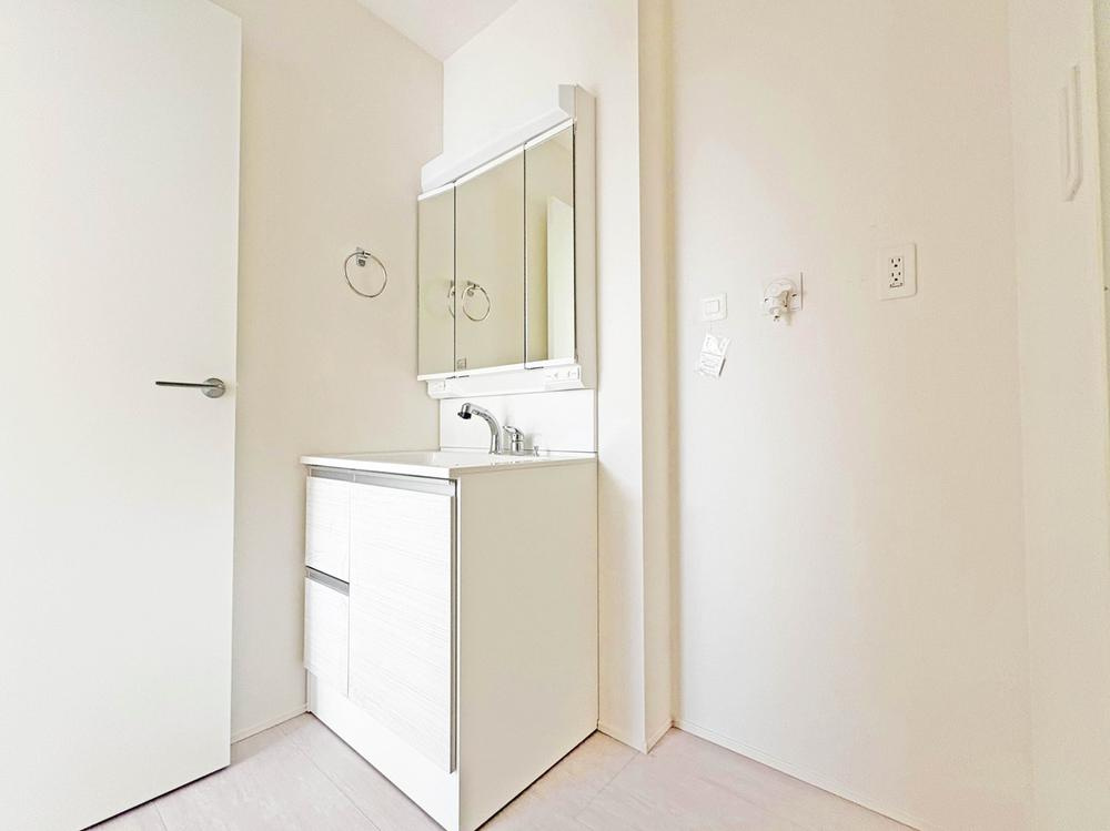 【GRAFARE　ZEH水準仕様】小平市上水新町３期全15棟の洗面所|機能美とデザイン性を両立させた3面境仕上げの洗面化粧台。
毎日利用する洗面脱衣場はシンプルで清潔感のある空間。ドラム式洗濯機も置くことができます。
