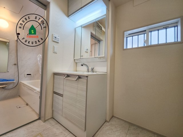 福岡市東区高美台1丁目第1-2棟（1号棟）の内観：施工例|毎日使うものだから清潔な空間を保ちたい水回り。洗面にはそんな願いを解消させてくれる収納アイデアが満載です。三面鏡の裏側にはキャビネットが現れ小物から背の高い物まで収納できます。