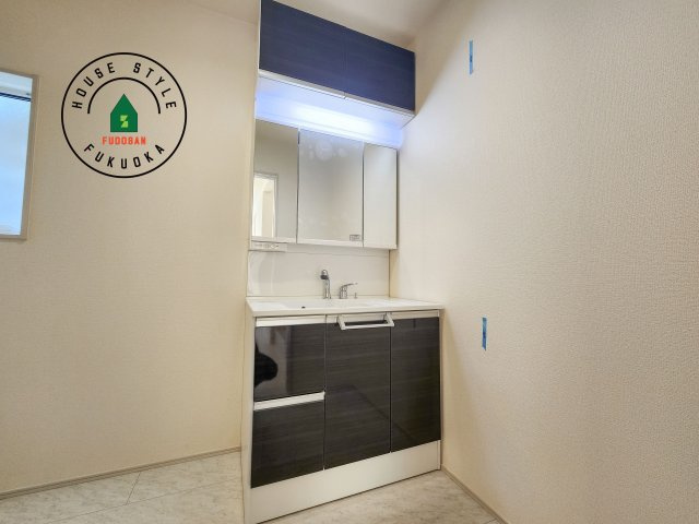 福岡市東区高美台1丁目第1-2棟（2号棟）の内観：施工例|毎日使うものだから清潔な空間を保ちたい水回り。洗面にはそんな願いを解消させてくれる収納アイデアが満載です。三面鏡の裏側にはキャビネットが現れ小物から背の高い物まで収納できます。