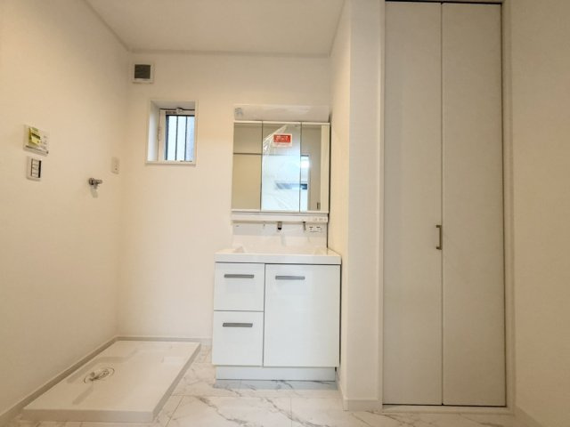 新築戸建　大東市三箇1丁目の洗面所|「朝の支度もスムーズに」
洗面台横に収納を設けた、使い勝手の良い設計。
家族全員のタオルや洗剤類もまとめて収納でき、散らかりにくい清潔空間。
明るい白基調で、朝の支度も気持ちよくスタート。