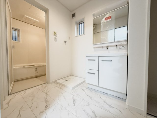 新築戸建　大東市三箇1丁目の独立洗面台|「家事と身支度が重なる時間も、心地よく。」
白を基調にした清潔感あふれる洗面スペース。
洗濯機横には収納スペースがあり、洗濯→干す→しまうの動線がスムーズ。
