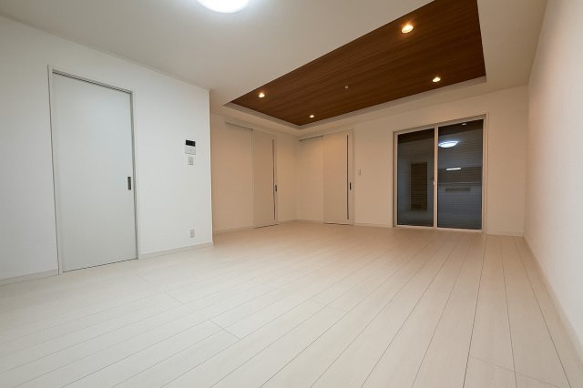 新築戸建　大東市三箇1丁目の居間・リビング|LDKは約18帖の広々空間。木目の織り上げ天井とダウンライトが調和し、温もりと高級感を演出します。