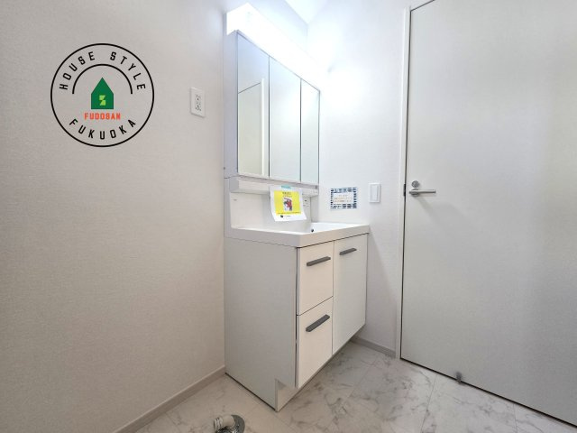 福岡市東区千早1丁目第2-2棟(1号棟)の内観：施工例|毎日使うものだから清潔な空間を保ちたい水回り。洗面にはそんな願いを解消させてくれる収納アイデアが満載です。三面鏡の裏側にはキャビネットが現れ小物から背の高い物まで収納できます。