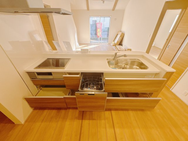 【ブルーミングガーデン】　宇都宮市花房1丁目　限定1邸のキッチン|○キッチンから○
大きな鍋やフライパンを収納できるスライド収納が完備されています。小さなお子様とも料理を楽しめるＩＨクッキングヒーター、後片付けもラクラクな食器洗乾燥機付！
※2025年10月撮影