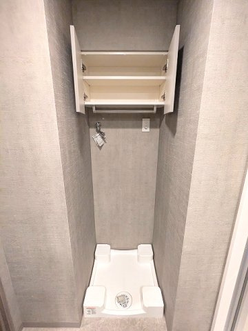 Dimus根岸の設備|室内洗濯機置場は排水溝のお手入れがし易い様に中央手前に配置し、足高の防水パンです、洗濯機置場上部収納したにハンガーストックバー付です