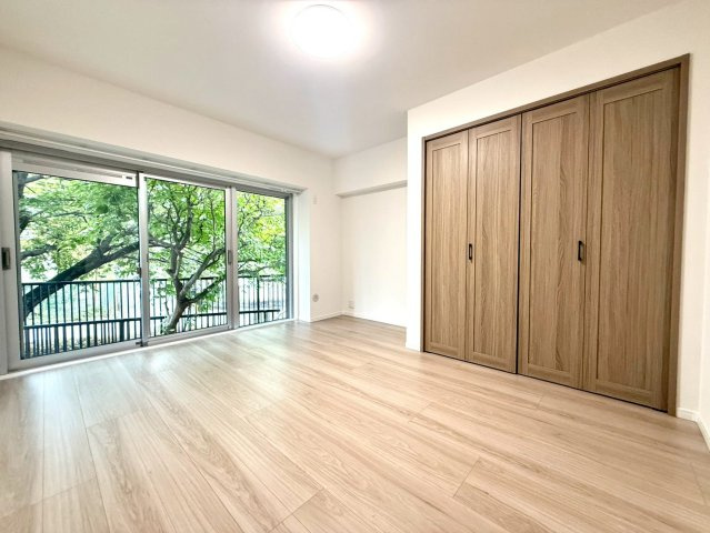 メゾンドール多摩川の洋室|三枚引きの大きな窓が特徴の洋室。たっぷりの陽光と緑の眺めを取り込み、開放感のある明るい居住空間です。