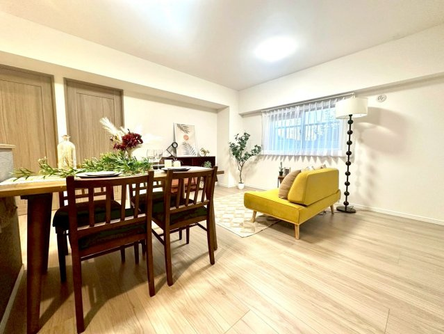 メゾンドール多摩川の居間・リビング|木目の美しいフローリングとホワイトクロスが調和した明るいLDK。広々とした空間が家族の団らんを包みます。