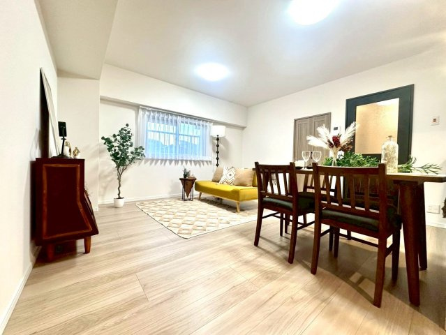 メゾンドール多摩川の居間・リビング|キッチンとリビングが一体となった開放的な設計。照明や建具のトーンを揃え、上質な統一感を演出しています。