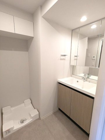 Urbanex新御徒町駅前の洗面所|トイレと独立した洗面室、三面鏡付ハンドシャワー付、鏡の後ろも収納です、洗濯機置場は排水口のお手入れをしやすく中央手前に配置し、足高の防水パン