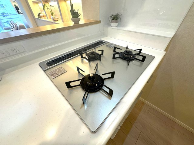 コーポ押上のキッチン|3口ガスコンロで、同時調理もスムーズに。忙しい毎日にうれしい機能です。ガラストップコンロはスタイリッシュなデザインで、掃除が簡単、汚れがつきにくいなどのメリットがあります。