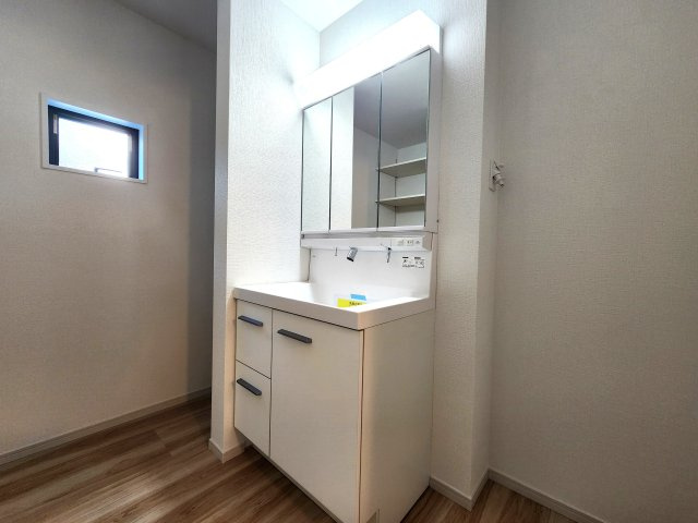 福岡市西区愛宕浜第1-3棟（1号棟）　の内観：施工例|毎日使うものだから清潔な空間を保ちたい水回り。洗面にはそんな願いを解消させてくれる収納アイデアが満載です。三面鏡の裏側にはキャビネットが現れ小物から背の高い物まで収納できます。