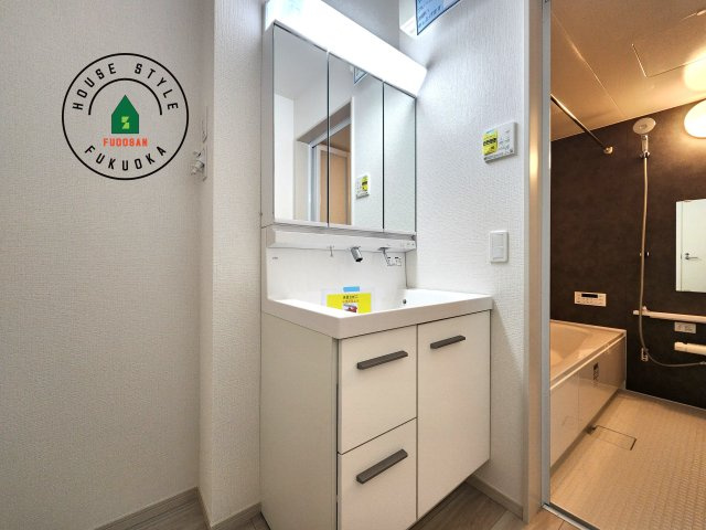 福岡市西区愛宕浜第1-3棟（3号棟）　の内観：施工例|毎日使うものだから清潔な空間を保ちたい水回り。洗面にはそんな願いを解消させてくれる収納アイデアが満載です。三面鏡の裏側にはキャビネットが現れ小物から背の高い物まで収納できます。