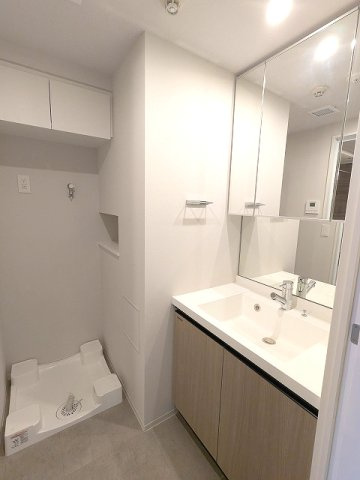 Urbanex新御徒町駅前の洗面所|トイレと独立した洗面室、三面鏡付ハンドシャワー付、鏡の後ろも収納です、洗濯機置場は排水口のお手入れをしやすく中央手前に配置し、足高の防水パン