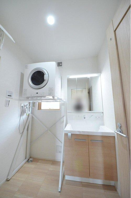 八木6丁目の洗面所|清潔感あふれる白を基調としたシャワー付洗面台と洗面室。収納棚もある余裕のスペース。窓もあり明るく通気も良いです。