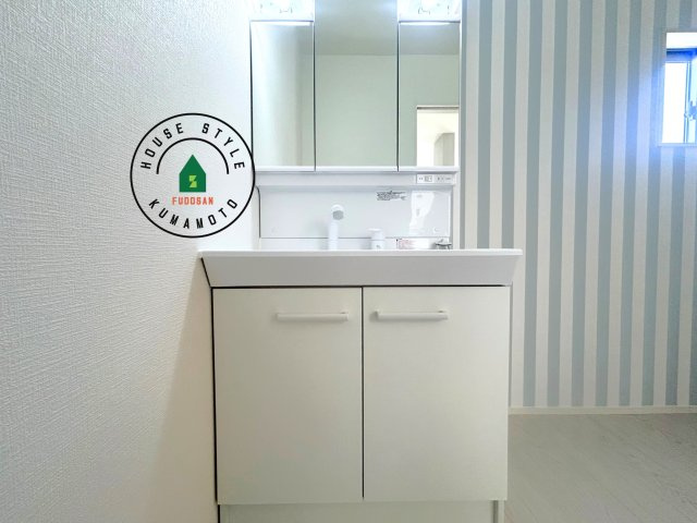 合志市須屋第10-2棟（2号棟）　の内観：施工例|毎日使うものだから清潔な空間を保ちたい水回り。洗面にはそんな願いを解消させてくれる収納アイデアが満載です。三面鏡の裏側にはキャビネットが現れ小物から背の高い物まで収納できます。