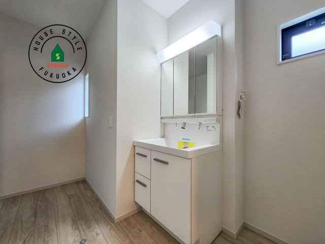 太宰府市高雄6丁目第3-2棟(2号棟)の独立洗面台|毎日使うものだから清潔な空間を保ちたい水回り。洗面にはそんな願いを解消させてくれる収納アイデアが満載です。三面鏡の裏側にはキャビネットが現れ小物から背の高い物まで収納できます。