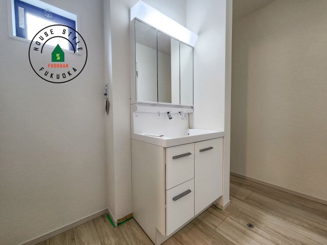 福岡市西区小戸3丁目第4-3棟(1号棟)の内観：施工例|毎日使うものだから清潔な空間を保ちたい水回り。洗面にはそんな願いを解消させてくれる収納アイデアが満載です。三面鏡の裏側にはキャビネットが現れ小物から背の高い物まで収納できます。