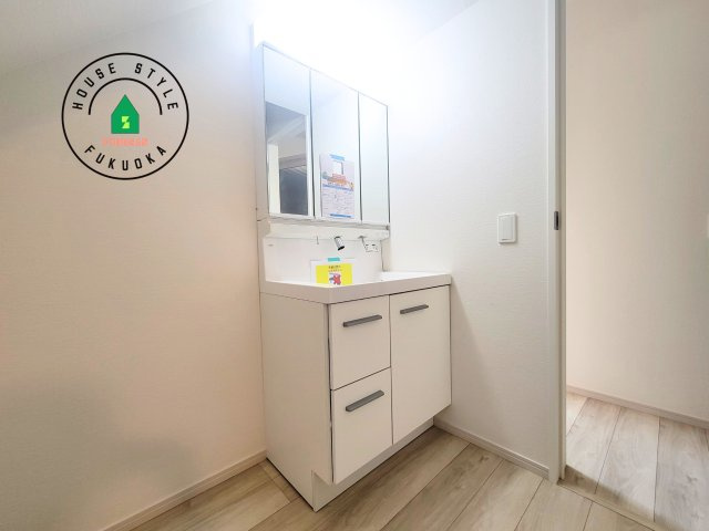 福岡市東区千早1丁目第2-2棟(1号棟)の内観：施工例|毎日使うものだから清潔な空間を保ちたい水回り。洗面にはそんな願いを解消させてくれる収納アイデアが満載です。三面鏡の裏側にはキャビネットが現れ小物から背の高い物まで収納できます。