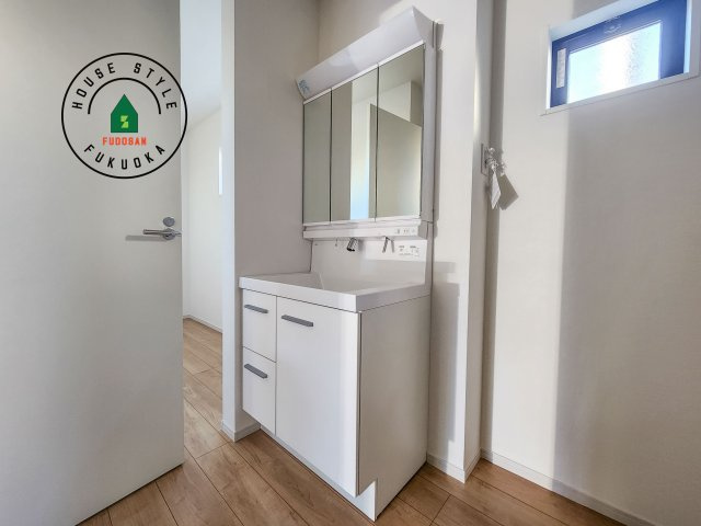 糟屋郡志免町片峰4丁目第4-2棟（2号棟）の内観：施工例|毎日使うものだから清潔な空間を保ちたい水回り。洗面にはそんな願いを解消させてくれる収納アイデアが満載です。三面鏡の裏側にはキャビネットが現れ小物から背の高い物まで収納できます。