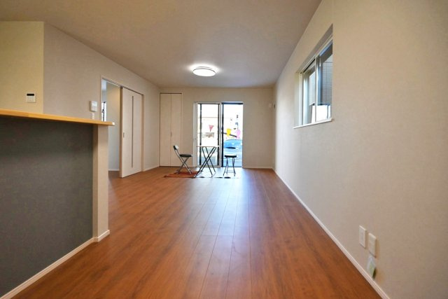 ファーストタウン大吹町新築一戸建て│3SLDK+並列駐車2台可の居間・リビング|ダイニング側から撮影した写真です。外に向かって大きく開けた窓から自然光が差し込む明るい空間です。