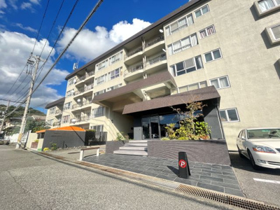 【外観】 | 宝塚御殿山マンション | ビンテージマンションならではの解放感と重厚感が感じられます。車路の奥にも駐車場があります。エントランス横には集会室があります。