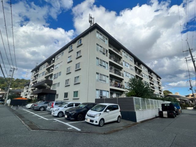 【外観】 | 宝塚御殿山マンション | ビンテージマンションならではの解放感と重厚感が感じられます。車路の奥にも駐車場があります。エントランス横には集会室があります。